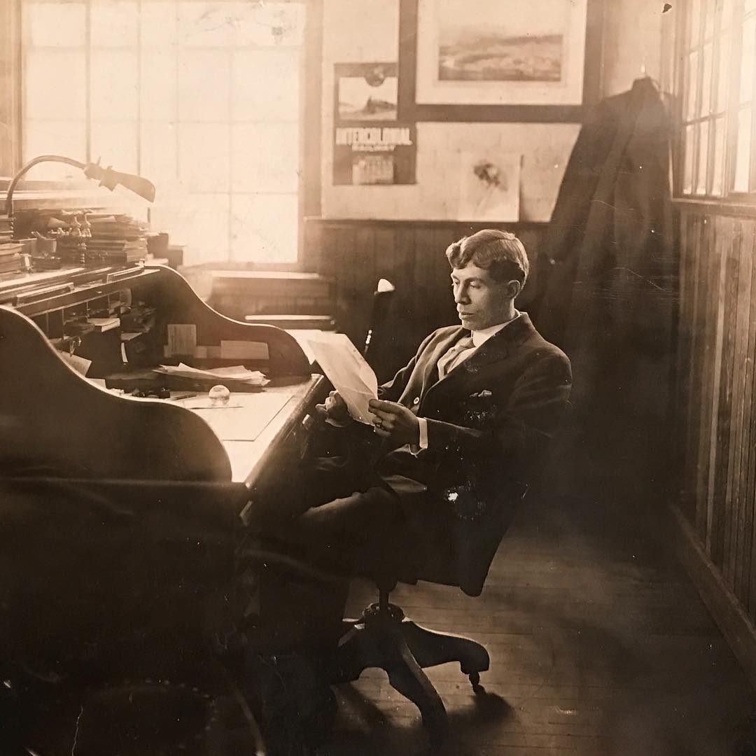 Clyde Yost reading at his desk in his office